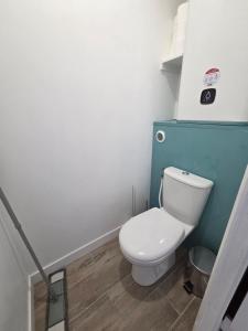 a bathroom with a white toilet and a blue wall at La Parenthèse, studio in Gruissan