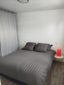 a bedroom with a large bed with a red teddy bear at Petite maison meublée in Landévant