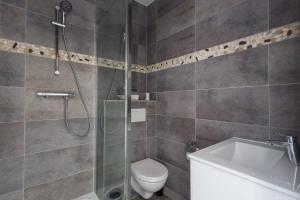 a bathroom with a shower and a toilet and a sink at The Pearl in Vitry-sur-Seine