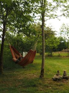 a person sleeping in a hammock in a park at Glamping Tent Celte du Morvan, Vrij in de Natuur in La Tagnière