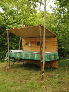 a wooden play house with a roof in the grass at Glamping Tent Celte du Morvan, Vrij in de Natuur in La Tagnière