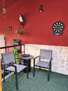 two chairs and a table and a dartboard on a wall at El Torreón in Valderredible