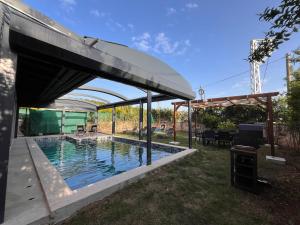 a swimming pool under a pavilion next to a house at Derya Beach Agullu Villa 5 in Kaş