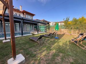 a group of chairs and an umbrella in a yard at Derya Beach Agullu Villa 5 in Kaş