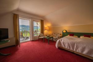 a hotel room with a bed and a large window at Hotel Drachenwand-Mondsee in Mondsee