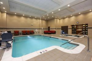 una piscina en una sala de hospital con una zona de espera y sillas en Hilton Garden Inn Clifton Park en Clifton Park