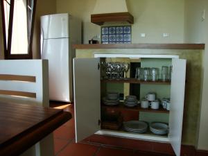 una cucina con un mobile con piatti e un frigorifero di Alma Pampa a Chascomús