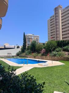 a swimming pool in a park with tall buildings at Bright Flat 1 min from Beach with parking in Fuengirola