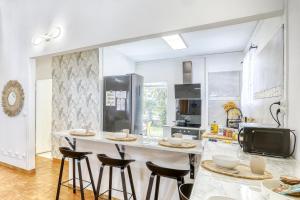 a kitchen with a large island with bar stools at La Villa Des Lys avec jacuzzi in Saint-Denis