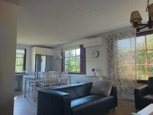 a living room with a couch and a dining room at Kuivasjärvi House in Oulu