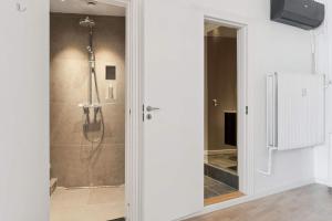 a bathroom with a shower with a glass door at John F Kennedys Suite in Aalborg +13 photos