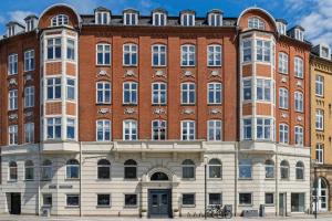 a large red brick building with many windows at John F Kennedys Suite in Aalborg