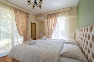 a bedroom with a bed with white sheets and a window at Apartments Nina in Athens +67 photos