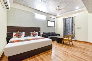 a bedroom with a bed and a desk and a couch at FabHotel Kirara - Nr Jaipur International Airport in Jaipur +29 photos