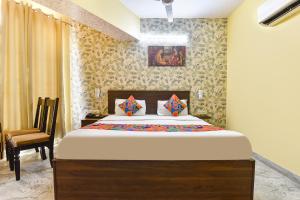 a bedroom with a bed and a chair at FabHotel Kirara - Nr Jaipur International Airport in Jaipur