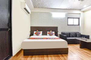 a bedroom with a large bed and a couch at FabHotel Kirara - Nr Jaipur International Airport in Jaipur
