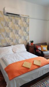 a bedroom with a bed with an orange blanket at Csilla Home Apartman in Miskolc