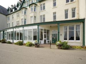 a large white building with windows on the side of it at Dornoch Hotel 'A Bespoke Hotel' in Dornoch