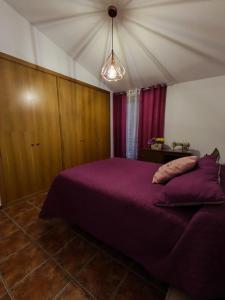 a bedroom with a purple bed in a room at El Torreón in Valderredible