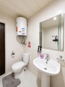 a bathroom with a toilet and a sink at Boston Hotel Tashkent in Yakkasaray