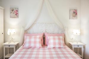 a bed with pink and white checkered sheets and pillows at Ksenija Apartments in Tučepi
