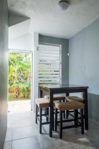 een eetkamer met een houten tafel en stoelen bij Tropical Getaway in Aguadilla