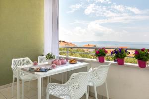a breakfast table on a balcony with a view of the ocean at Ksenija Apartments in Tučepi