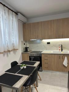 a kitchen with a table and a table and a kitchen with a sink at AirbnbTzo in Perístasis +2 photos