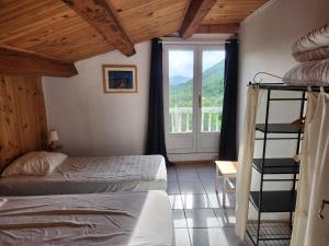 a bedroom with a bed and a window at Grand Gite des Jourdets in Lairière