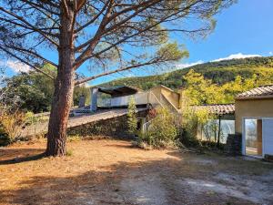 a house with a tree next to a building at Grand Gite des Jourdets in Lairière