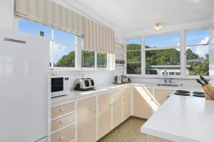 a kitchen with white cabinets and a white counter top at Kakanui Ocean Views in Kakanui
