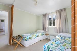 a bedroom with two beds and a mirror at Kakanui Ocean Views in Kakanui