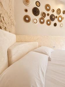 ein Schlafzimmer mit einem weißen Bett und einigen Tellern an der Wand in der Unterkunft Blue Mill Resort, Sarande in Mesopotam + 5 Fotos