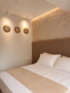 ein Schlafzimmer mit einem Bett und zwei Uhren an der Wand in der Unterkunft Blue Mill Resort, Sarande in Mesopotam