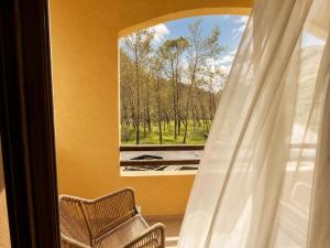 ein Zimmer mit einem Fenster mit einem Stuhl und einer Aussicht in der Unterkunft Blue Mill Resort, Sarande in Mesopotam