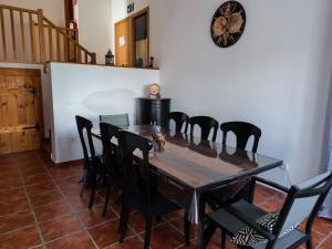 a dining room table with black chairs and a clock on the wall at El Torreón in Valderredible +25 photos