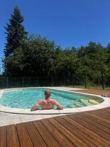 a man is sitting in a swimming pool at Glamping Tent Celte du Morvan, Vrij in de Natuur in La Tagnière