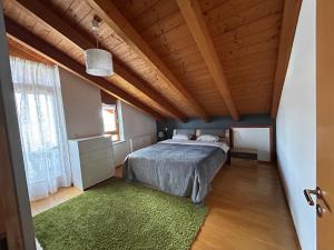 a bedroom with a bed and a wooden ceiling at Staufen Blick in Piding