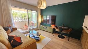 a living room with a couch and a table at Studio Golfe Juan bord de mer - parking & piscine in Vallauris