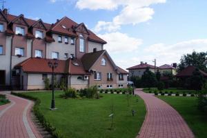 una fila de casas con un patio de césped al lado de una carretera en Motel Zacisze, en Łomża