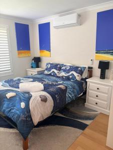 a bedroom with a bed with blue and white sheets at a perfect weekend getaway in Rockingham +12 photos
