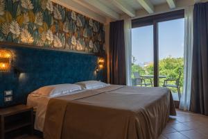 a bedroom with a bed and a large window at Palazzo della Scala Hotel - Luxury Suites & Spa in Lazise +112 photos