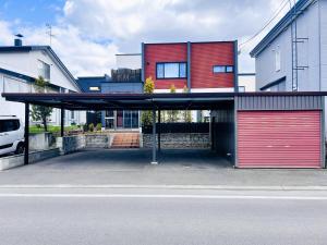 a parking lot with a red building with a garage at Stay923 in Asahikawa