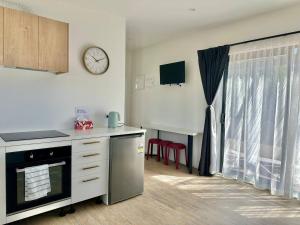 a kitchen with a counter and a clock on the wall at Settlers Nook Oamaru in Oamaru