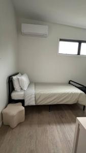 a bed sitting in a room with a window at Settlers Nook Oamaru in Oamaru