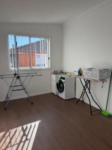 a room with a washing machine and a window at Second Home - A modern 4 Bedrooms House in Blacktown
