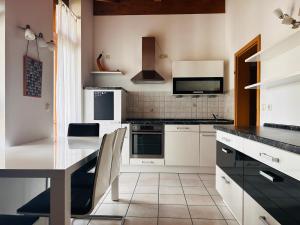 a kitchen with white cabinets and a black counter top at Staufen Blick in Piding