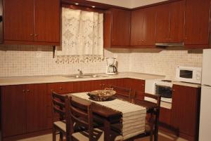 a kitchen with a table with chairs and a microwave at Oreini Nafpaktia Houses in Palaiópirgos