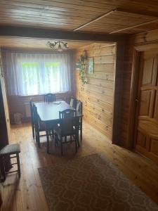 a dining room with a table and chairs at Domek Pod Skansenem in Białowieża