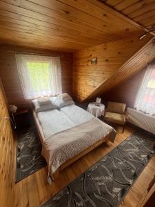 a bedroom with a bed in a wooden cabin at Domek Pod Skansenem in Białowieża +26 photos